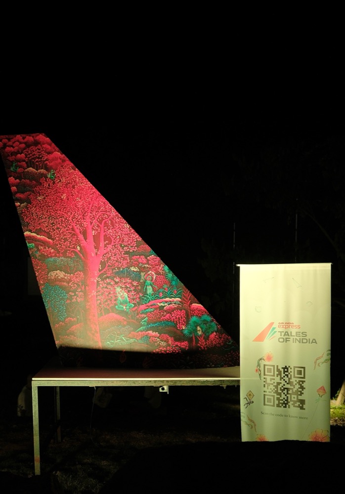 An illuminated Air India Express tail-fin art installation at night